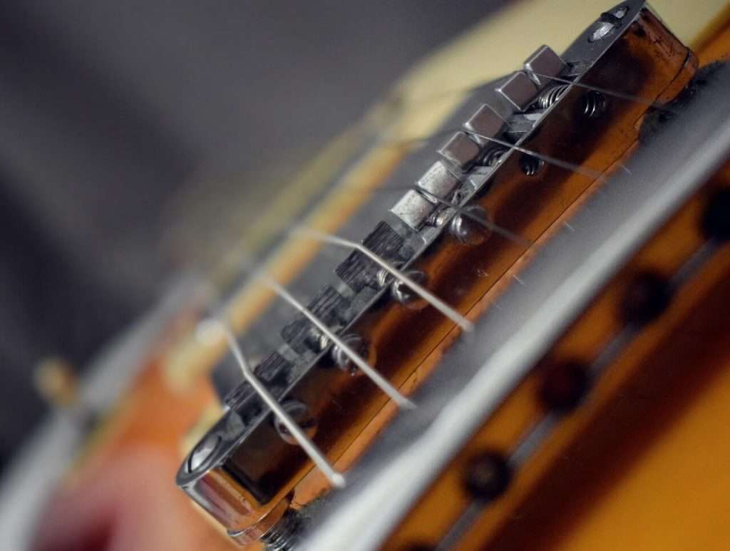 What is a MIDI pickup and how does it work: a zoomed photo of an electric guitar bridge and pickups.